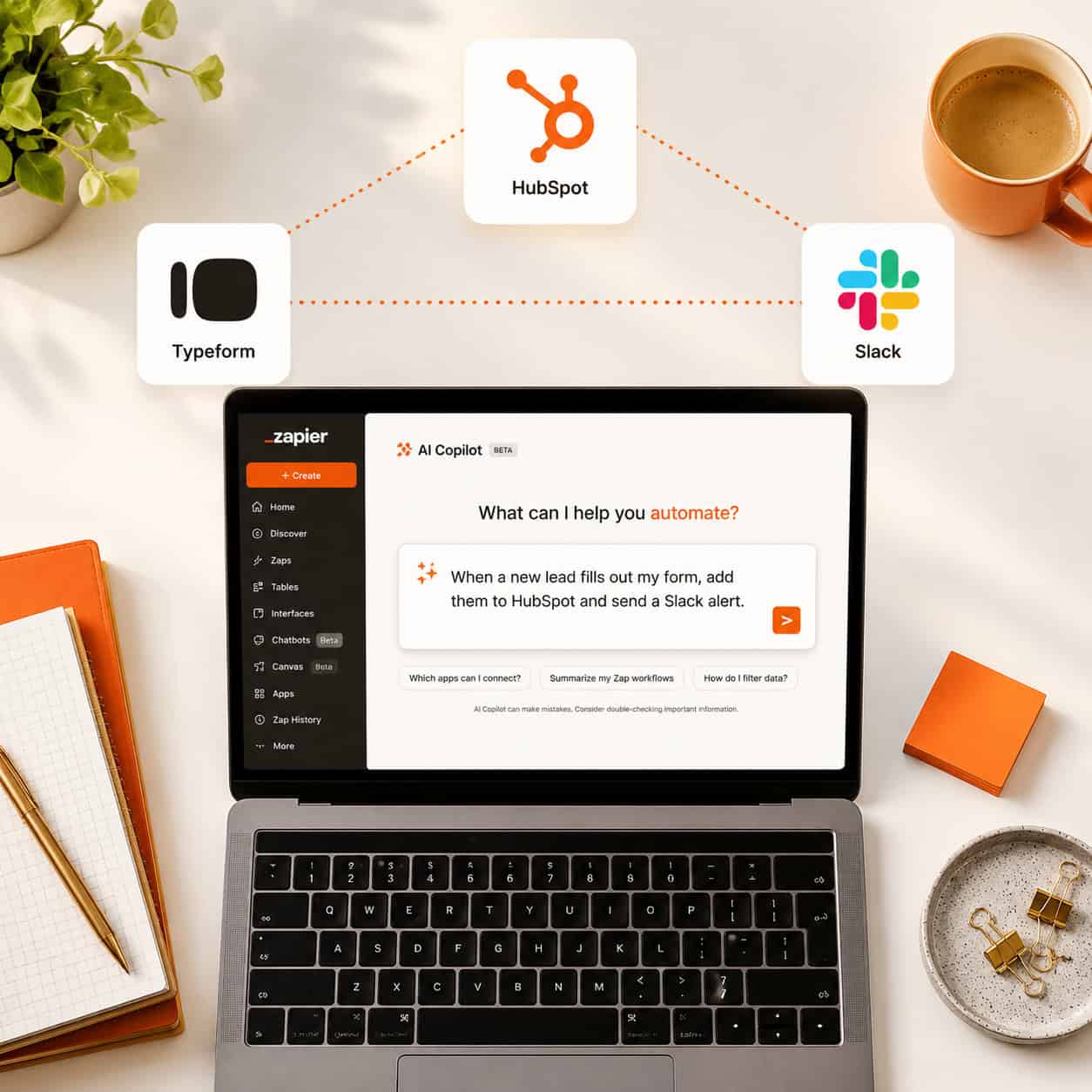 () overhead flat-lay style image of a modern workspace desk featuring a laptop screen displaying the Zapier AI Copilot chat